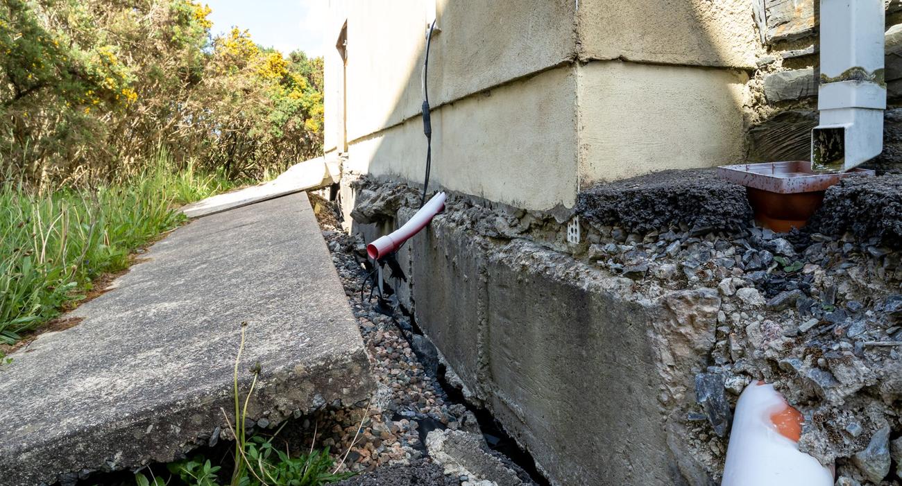 A pavilion hit by a crane after land subsidence threatens to collapse